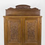 Credenzina in noce con alzata e sportelli lavorati a bassorilievo. Francia inizi '900